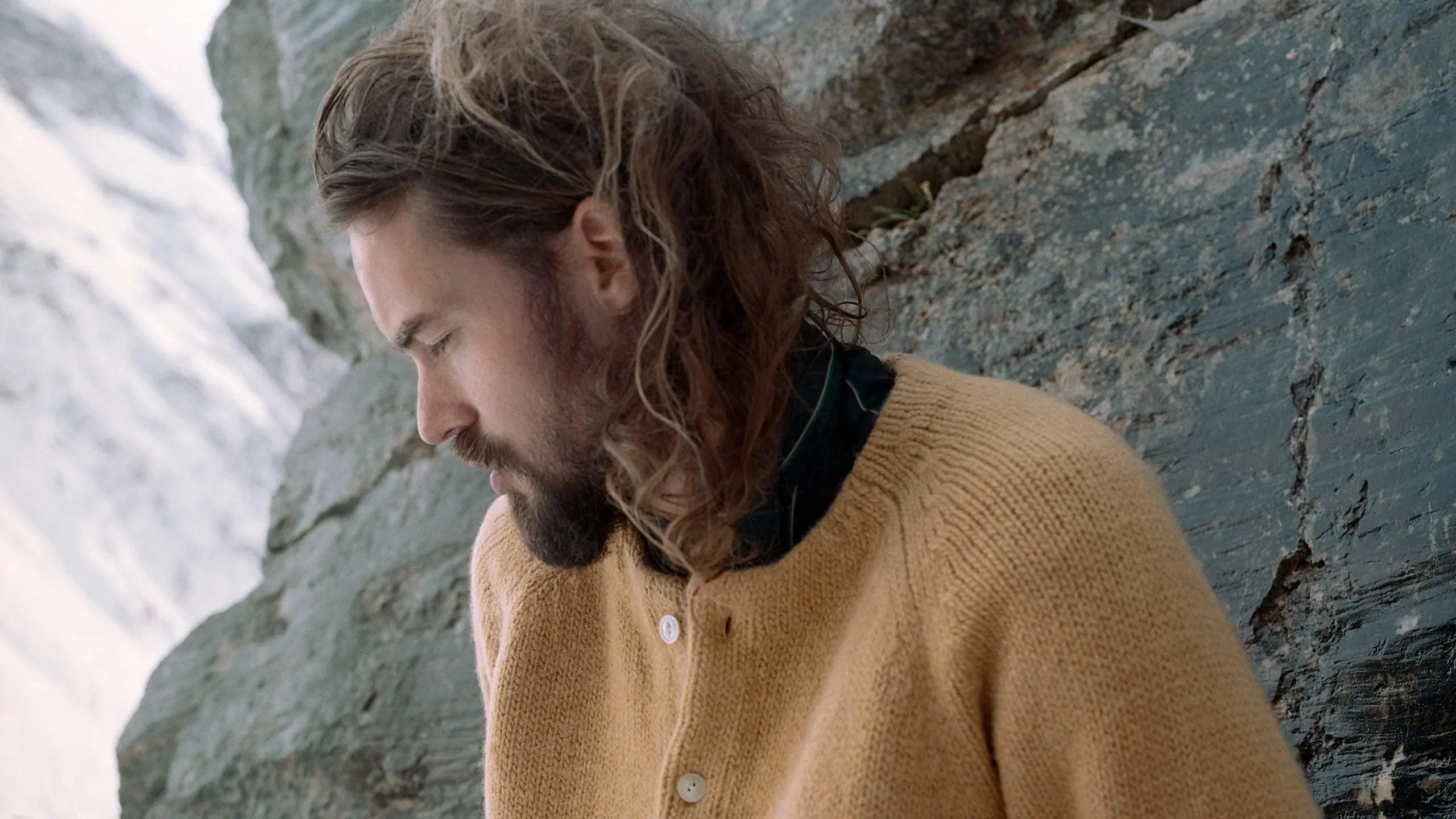 Photograph of French Perfumer, Barnabé Fillion, outdoors against a sedimentary natural landscape.  