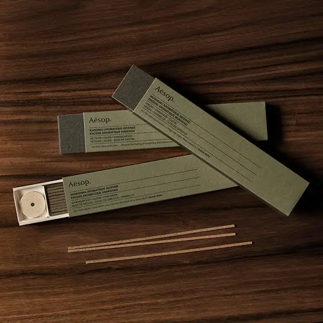 Three cartons of incense resting on a wooden surface.