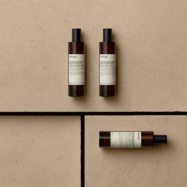 Three glass Room Spray bottles resting on a cardboard surface.